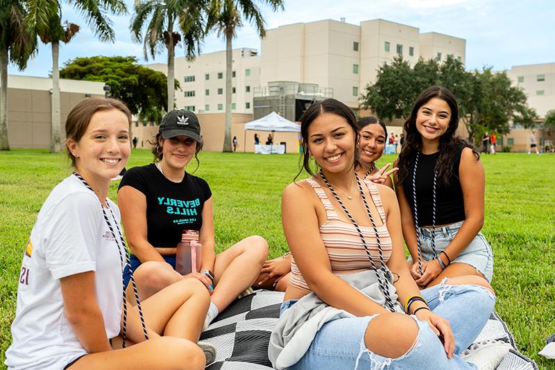 a group of student hanging out together on the Housing Lawn during Red and Blue Weeks